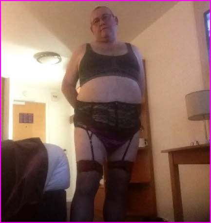 Married man cross-dressing in a black bra, knickers and stockings